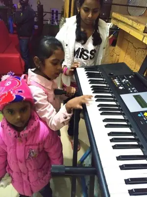 two young girls standing next to a keyboard at A Ooty Honey Huts in Ooty