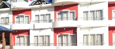 a red and white building with windows at A Ooty Honey Huts in Ooty