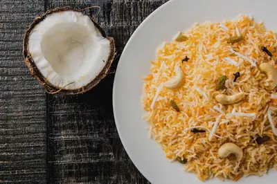 a plate of rice and mushrooms on a table at Hotel O Al Ameen Residency in Kannur