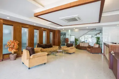 a large lobby with couches and chairs and a table at THE CASTELLO RESIDENCY in Coimbatore