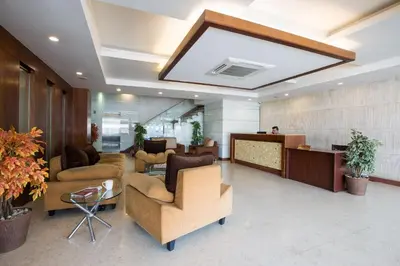 a lobby with couches and chairs in a building at THE CASTELLO RESIDENCY in Coimbatore