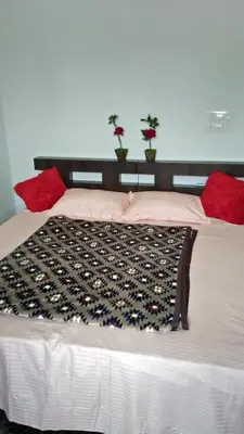 a bed with red pillows on top of it at Chamayam Holiday Villa in Meenangadi