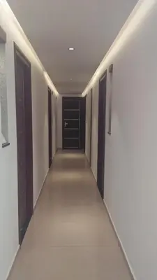 a hallway with black doors and white walls at LEMON RESIDENCY By Chungath in Trichūr
