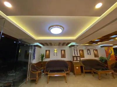a lobby with chairs and a ceiling with a light at Utsavam Hotel Apartments in Guruvāyūr