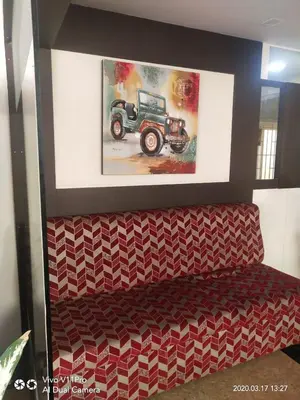 a bench with a picture of a truck on the wall at Sri Kamadhenu Residency in Coimbatore