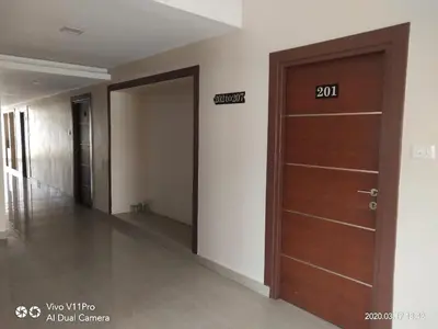 a hallway with a door with a sign on it at Sri Kamadhenu Residency in Coimbatore