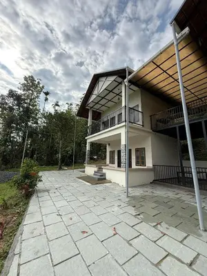 a large white building with a large patio at Caffeine Villa in Kaniyāmbetta