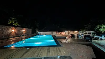 a swimming pool in a parking lot at night at Caffeine Villa in Kaniyāmbetta