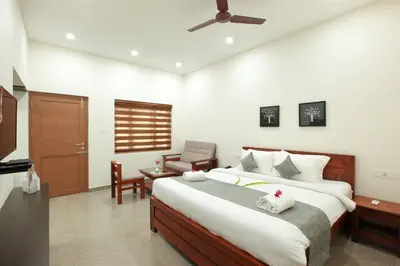 a bedroom with a large bed and a chair at Green Planet Resort in Mattanūr