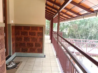 a balcony of a house with a brick wall at Green Planet Resort in Mattanūr