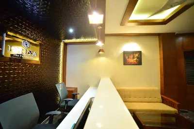 a restaurant with a table and chairs and a couch at Hotel Priya in Kottakkal