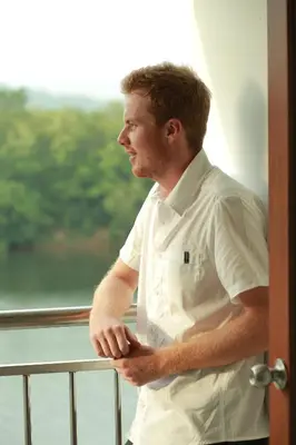 a man in a chefs uniform standing in front of a window at Hotel VKJ International Kuttampuzha in Thattakād