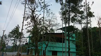 a blue building with trees in front of it at Wayanad Snow Vibes in Vythiri