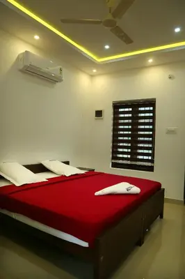 a bedroom with a red bed with a ceiling at karibu Residency in Malappuram