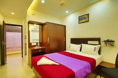 a bedroom with a large bed with a red and purple blanket at karibu Residency in Malappuram