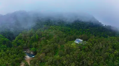 an aerial view of a forest with a house on a hill at Villa Tesori Homestay Wayanad in Meppādi