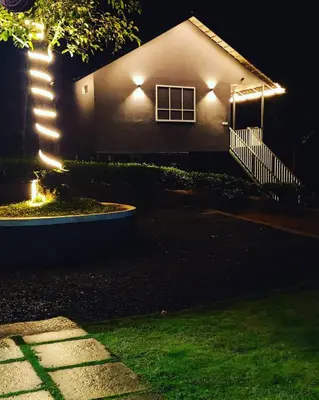 a house lit up at night with lights at Villa Tesori Homestay Wayanad in Meppādi
