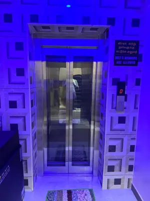 an elevator in a building with purple lights at Sakthimurugan residency in Erode