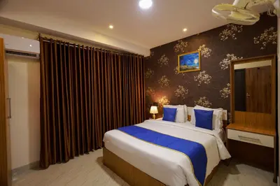 a bedroom with a large bed with blue pillows at Builda Park inn in Ottappālam