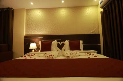 a bedroom with a large bed with red and white pillows at Builda Park inn in Ottappālam