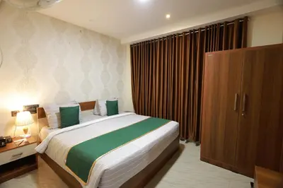 a bedroom with a large bed with green and white sheets at Builda Park inn in Ottappālam