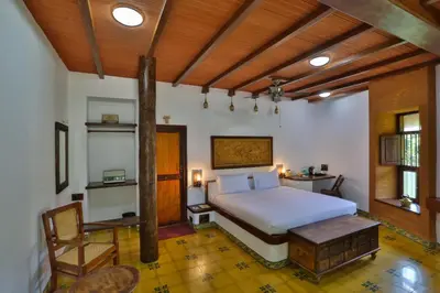 a bedroom with a white bed and a wooden ceiling at My Village - Eco Rural Resort in Coimbatore