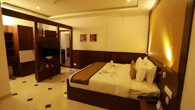 a hotel room with a bed and a television at Hotel Emperor in Kannur
