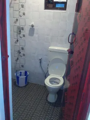 a bathroom with a white toilet in a stall at The Meadows in Kodaikānāl