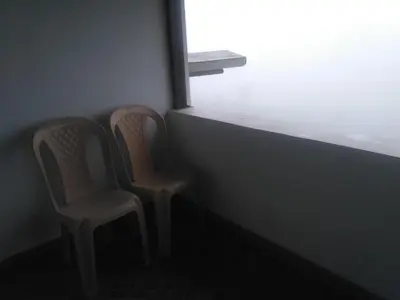 two chairs sitting in front of a window at The Meadows in Kodaikānāl
