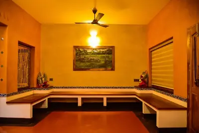 a living room with a couch and a ceiling fan at Chembra Adobe in Kalpetta