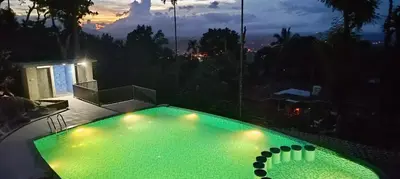 a small swimming pool with lights in the night at Chembra Adobe in Kalpetta