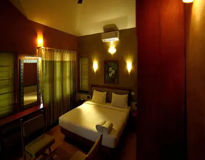 a bedroom with a white bed and a mirror at Chembra Adobe in Kalpetta