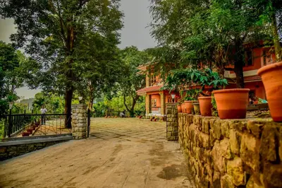 a stone wall with potted plants in front of a building at Chembra Adobe in Kalpetta