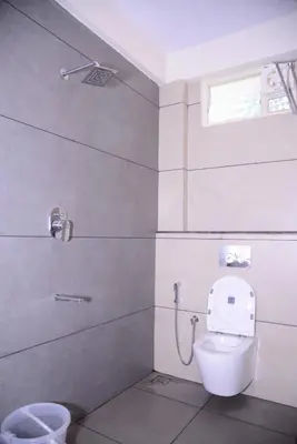 a bathroom with a toilet and a shower at Grand Misty Heaven in Madikeri
