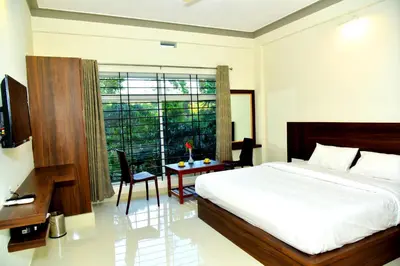 a bedroom with a bed and a table and a window at Grand Misty Heaven in Madikeri