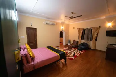 a bedroom with a bed and a living room at KINGMAKER'S Plantation with River Stream in Madikeri