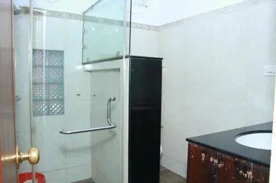 a bathroom with a glass shower and a sink at KINGMAKER'S Plantation with River Stream in Madikeri