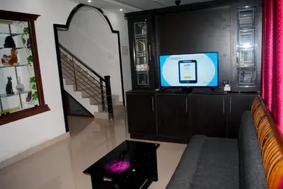a living room with a couch and a tv at NICE VILLA in Irimbranallūr