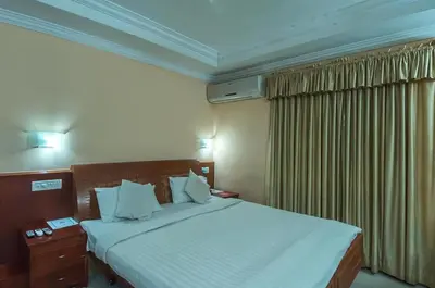 a hotel room with a large bed and a window at KPM Regency in Palakkad