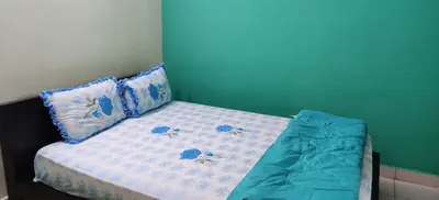 a bed with blue and white sheets and pillows at Garden House in Mysore