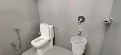 a bathroom with a toilet and a urinal and a sink at Garden House in Mysore