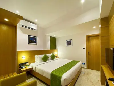 a hotel room with a bed and a television at Park Residency Kodungallur in Trichūr