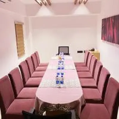 a conference room with a long table and pink chairs at Park Residency Kodungallur in Trichūr