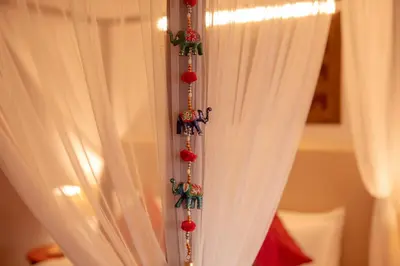 a curtain with christmas ornaments hanging from it at Tuskers Hill by Poppys Anaikatti in Palghat