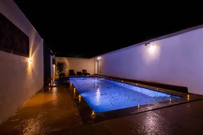 a large swimming pool in a building at night at Tuskers Hill by Poppys Anaikatti in Palghat