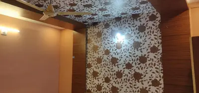 a ceiling fan in a room with a leopard print wall at Gateway Airport Hotel in Kannur