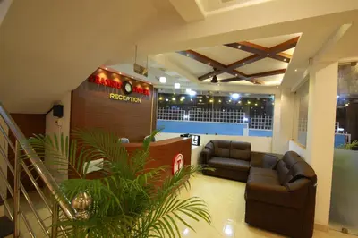 a lobby with a leather couch and a bar at Gateway Airport Hotel in Kannur