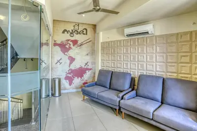 a living room with a couch and a map of the world at AS AIRPORT Inn in Cochin