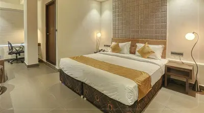 a bedroom with a large bed in a room at AS AIRPORT Inn in Cochin