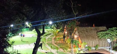 a group of people walking around a park at night at Ibni Springs in Madikeri